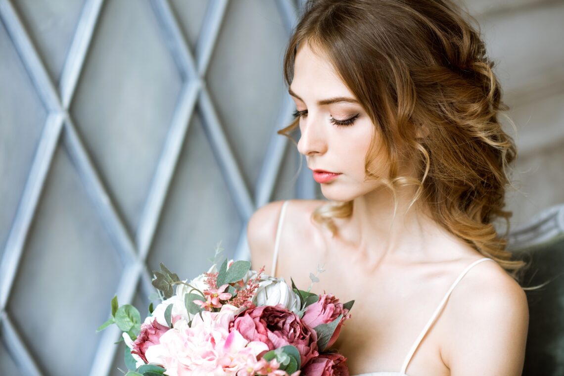 Closeup brunette bride with fashion wedding hairstyle and makeup