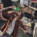 high angle view of man drinking from funnel while friends pouring alcohol beverages