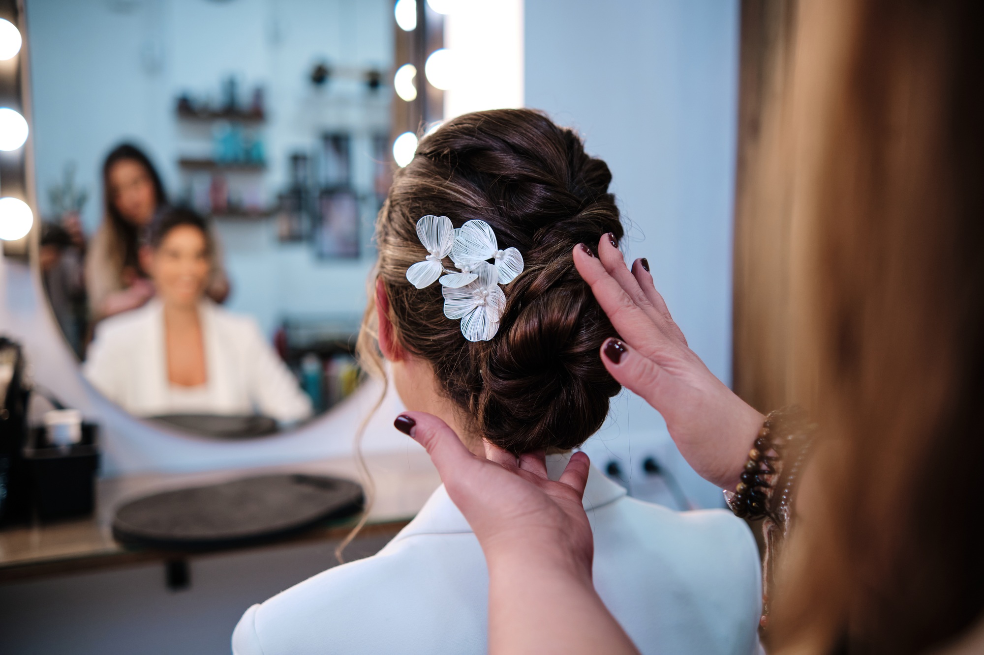 Stylist finishing a stylish hairstyle for a bride at the hair salon.