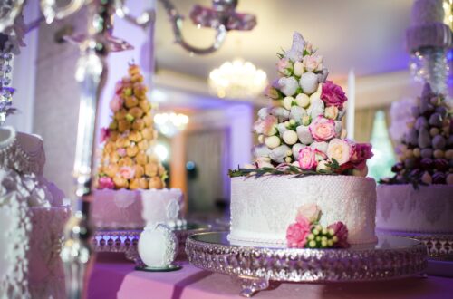 White wedding cake decorated with cream flowers on a stand